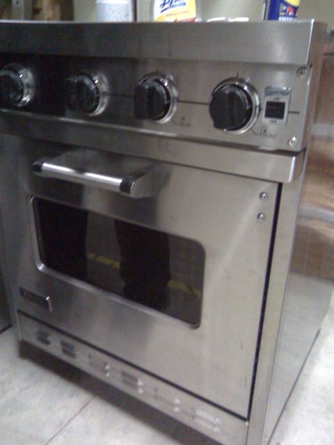 2006 Ford E350 - A stainless steel gas range oven with a glass window in the oven door and control knobs on the front panel.