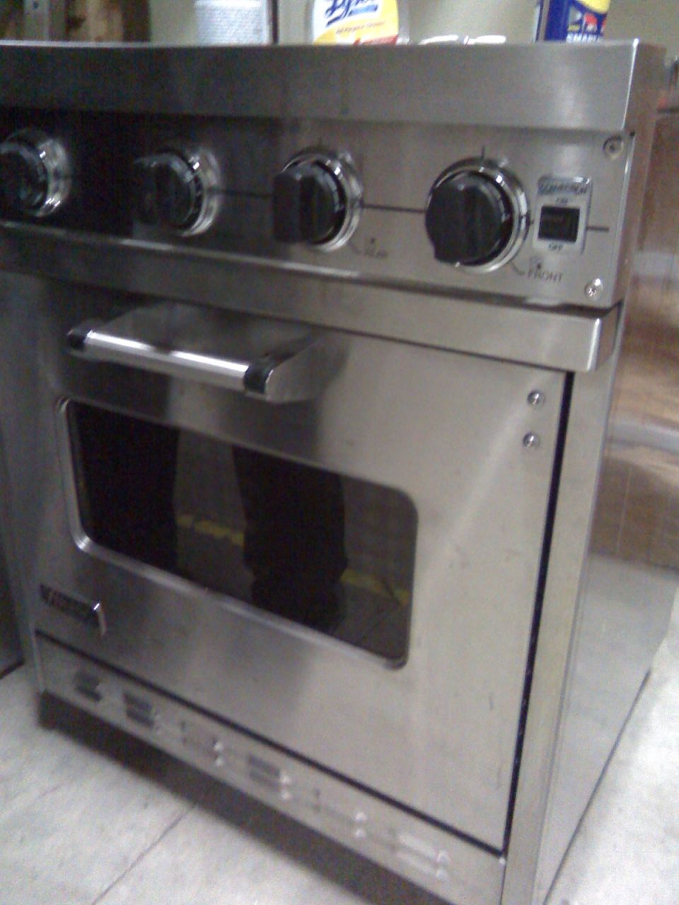 Stainless steel gas range oven with control knobs and oven window.