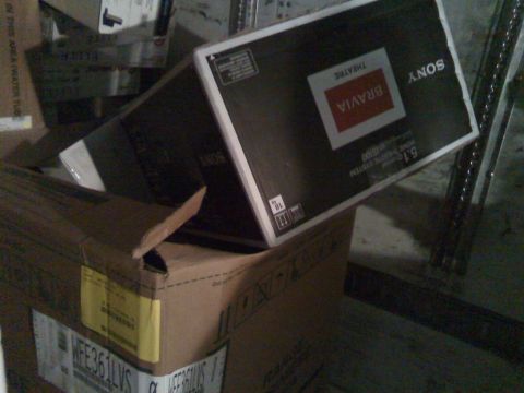 2006 Ford E350 - A Sony Bravia home theater system box is stacked on top of other cardboard boxes. One box has text that reads "WFE361LVS".