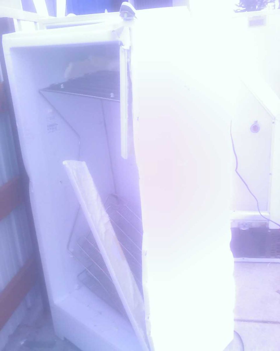 Interior of an open white refrigerator with wire shelves.
