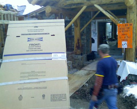 2006 Ford E350 - A construction site with large appliance boxes and a person walking by. A sign warns of a fine for leaving garbage on the job site.
