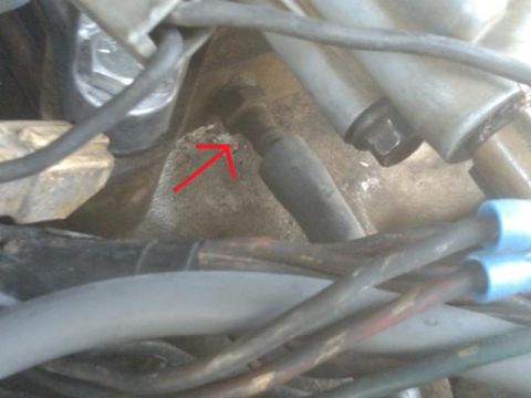 1982 Ford Bronco - Engine bay detail showing various wires and a bolt head indicated by a red arrow.