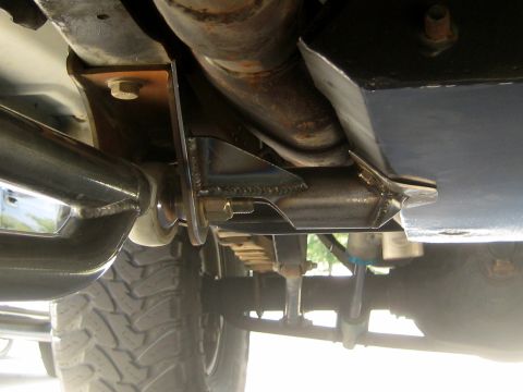 1996 Ford Bronco - Custom fabricated suspension components are visible on the underside of a vehicle, including welded brackets and exhaust piping.