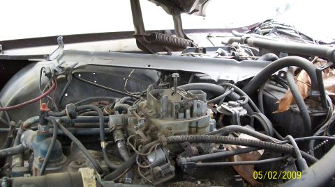 1972 Ford Ranchero - A close-up view of a vintage V8 engine bay, focusing on the carburetor and surrounding hoses and wiring. The engine appears to be in a stat…