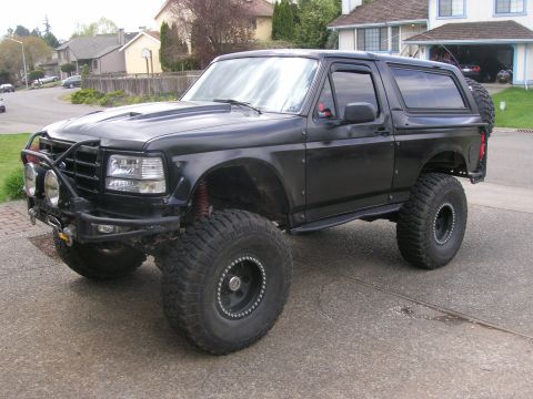 1996 Ford Bronco - This modified 1996 Ford Bronco features a lifted suspension, large off-road tires, and a custom front bumper with auxiliary lights.