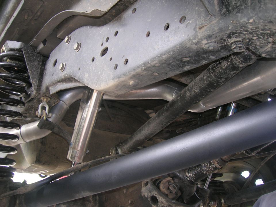 Underside of a lifted Ford Bronco with aftermarket shocks and exhaust.