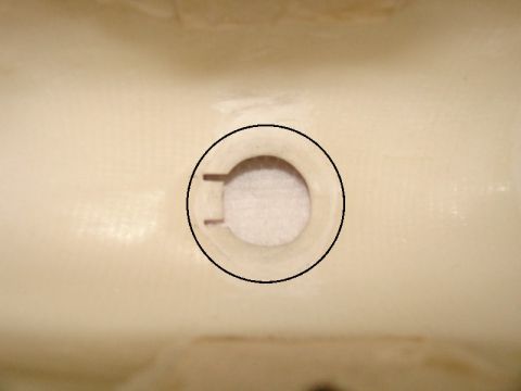 2003 Ford Crown Victoria - This is a close-up view of a plastic part with a circular opening and notches.