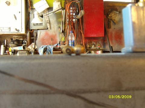 1989 Ford Bronco - A cluttered workbench with various tools, a water bottle, and electrical cords is visible in the background.