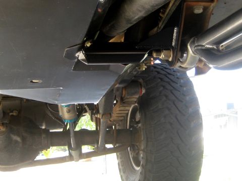 1996 Ford Bronco - Close-up view of a vehicle's underbody skid plate and suspension system.