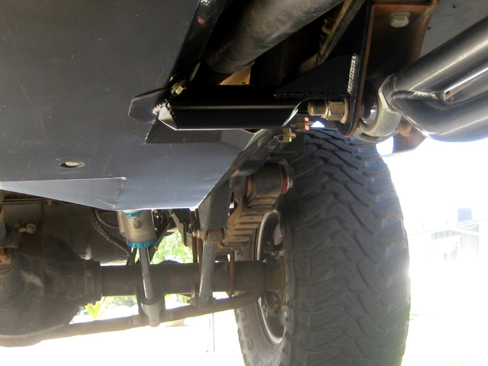 Underbody skid plate with suspension components and tire visible