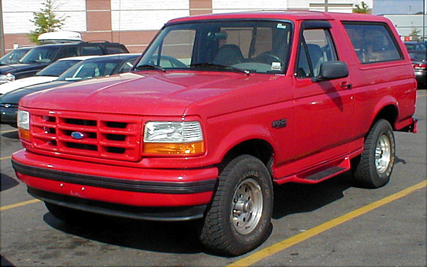 Red Ford Bronco SUV, front three-quarter view in a parking lot