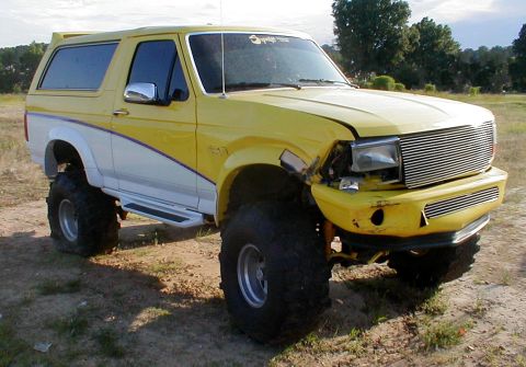 1983 Ford Bronco - This lifted Ford Bronco has a two-tone paint job and aftermarket wheels, but the front end shows damage.