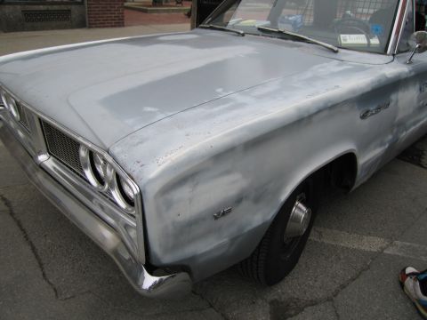 1991 Ford LTD Crown Victoria - Front quarter of a silver primer-finished vintage hardtop showing dual headlights, chrome bumper and a V8 fender emblem.