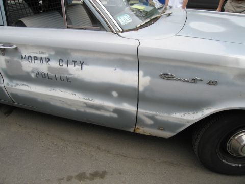 1991 Ford LTD Crown Victoria - Driver-side door of a worn silver sedan hand-lettered Mopar City Police, with a Coronet 440 fender emblem.