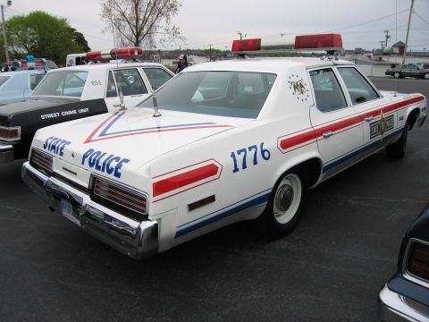 1991 Ford LTD Crown Victoria - white 'STATE POLICE' sedan marked '1776' with red and blue stripes and a roof lightbar, parked among patrol cars.