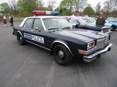 1991 Ford LTD Crown Victoria - black-and-white 'NORTH HAVEN POLICE' sedan with a red-and-blue roof lightbar parked among classic patrol cars.