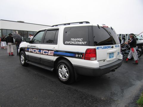 1991 Ford LTD Crown Victoria - white Ford Expedition marked Attleboro Police Traffic Enforcement with 911 lettering, viewed from the rear.