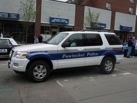 1991 Ford LTD Crown Victoria - white-and-blue Pawtucket Police Ford Explorer SUV marked Administration parked at the curb on a downtown street.
