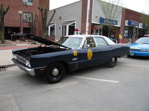 1991 Ford LTD Crown Victoria - dark-blue Plymouth Fury State Police sedan with gold door emblems and its hood propped open parked on a street.