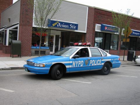 1991 Ford LTD Crown Victoria - vintage blue-and-white NYPD Police sedan parked at an angle on a downtown street outside the Asian Stir restaurant.