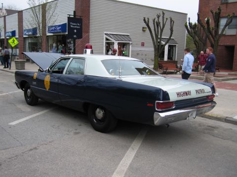 1991 Ford LTD Crown Victoria - Rear three-quarter view of a vintage dark-blue-and-white Highway Patrol sedan parked on a downtown street near shops.