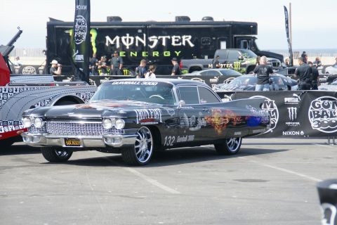 1993 Ford Taurus - A heavily customized classic Cadillac is displayed at an event, with a Monster Energy truck in the background.