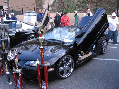 2001 Chevrolet Silverado 1500 - A modified black coupe with its doors open, surrounded by trophies at an outdoor event.
