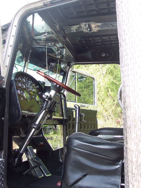 1981 Kenworth W900A - Customized interior of a large truck, a wooden steering wheel and polished metal dashboard.
