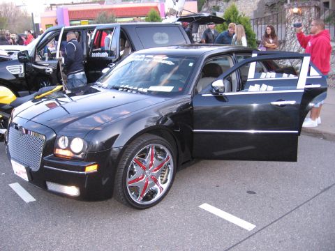 2001 Chevrolet Silverado 1500 - A black sedan is parked with its doors open, showing off its custom wheels and grille.