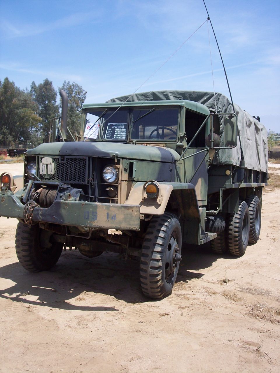 Front view of a camouflaged military cargo truck with a winch and canvas cover