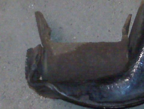 1995 Ford Bronco - A close-up view of a single, unidentifiable metal automotive part.
