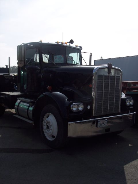 1981 Kenworth W900A - A black semi-truck is parked outdoors, with a 'For Sale' sign displayed on the windshield.