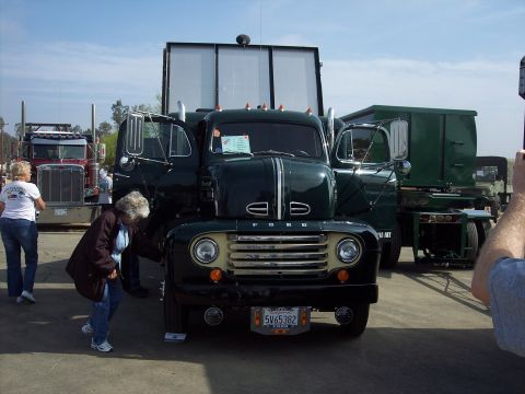 1981 Kenworth W900A - A dark green Ford truck from the 1950s is displayed with its doors open at an outdoor event.