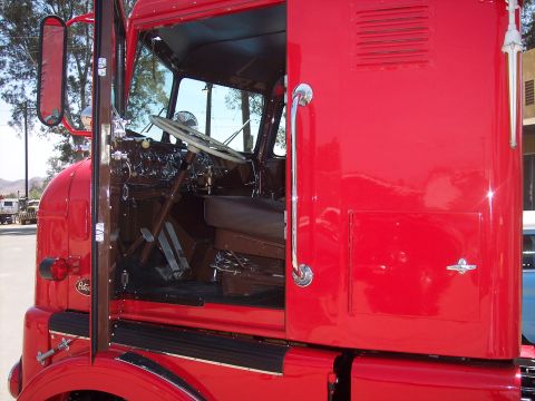 1981 Kenworth W900A - Interior view of a red semi-truck cab, showing the dashboard and seating area.