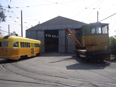 1981 Kenworth W900A - Two rail vehicles, a trolley and a crane, are parked outside a Los Angeles Railway maintenance building.