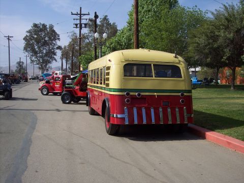 1981 Kenworth W900A - A vintage bus and tow truck are parked on a street during an event.