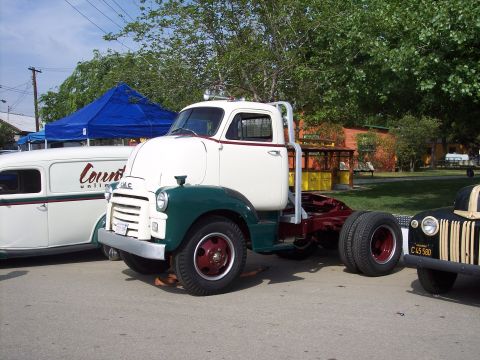 1981 Kenworth W900A - A vintage GMC truck is displayed at an outdoor event, alongside other vehicles.