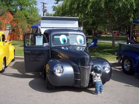 1981 Kenworth W900A - A vintage pickup truck with googly eyes is parked next to a yellow truck at an outdoor event.