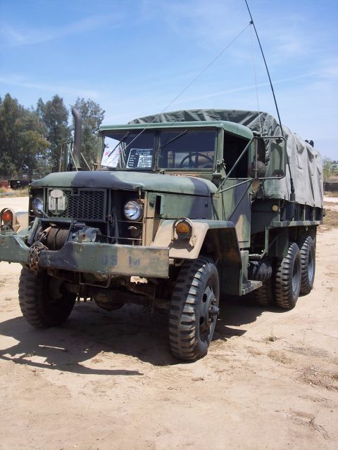 1981 Kenworth W900A - This military truck, possibly a M35 series, is seen from a three-quarter front view under a clear blue sky.