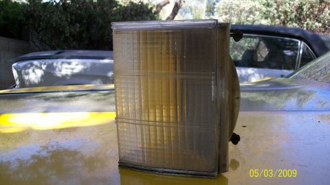 1972 Ford Ranchero - A clear turn signal assembly is shown on the hood of a yellow vehicle, with another car visible in the background.