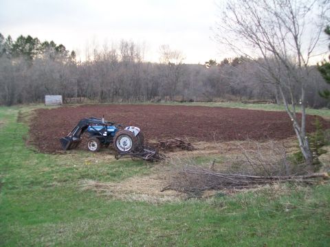 2000 Chevrolet Tahoe - Tractor working in a field, preparing the soil for planting.