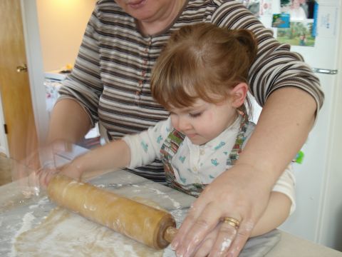 2000 Ford Crown Victoria - A child and adult work together to roll out dough on a floured surface with a wooden rolling pin.