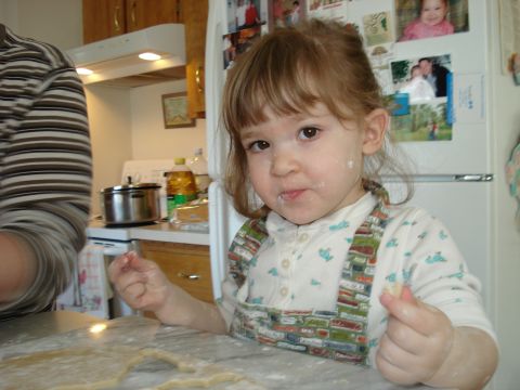 2000 Ford Crown Victoria - A child with flour on their face is in a kitchen, with dough on the counter.