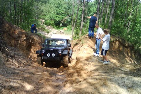 2008 Jeep Wrangler - A group of people watch as a Jeep Wrangler navigates a challenging off-road trail.
