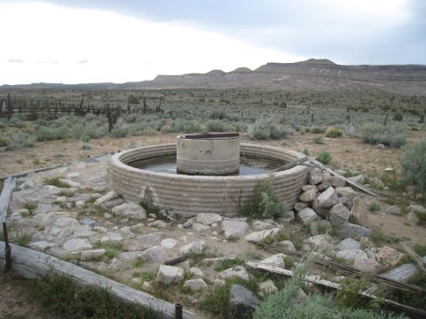 1994 Ford Bronco - An old water trough sits in a desolate, arid landscape under a cloudy sky.