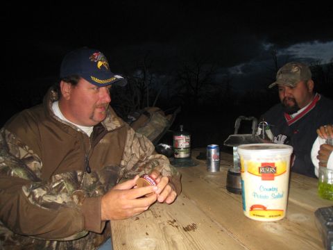 1994 Ford Bronco - Two men are gathered around a picnic table at night, with food and drinks laid out.