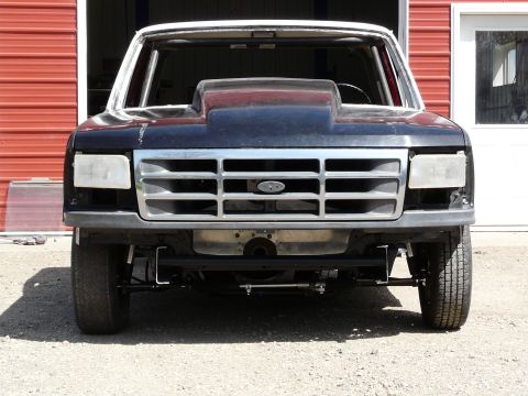 1994 Ford F-150 - Front view of a modified Ford truck with a custom hood scoop and roll cage.