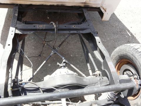 1994 Ford F-150 - The underside of a truck chassis reveals its rear axle and suspension components.