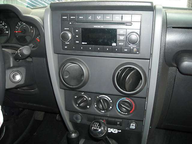 Jeep Wrangler JK interior showing dashboard, radio, air vents, and gear shifter