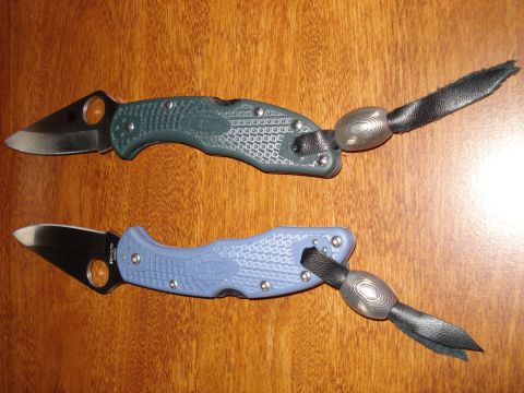 2000 Ford Crown Victoria - A pair of folding knives, one in green and the other in blue, are displayed with their attached lanyards.
